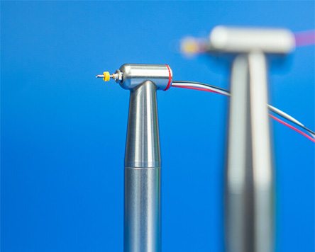 Contra-angle handpiece with integrated piezo actuator.